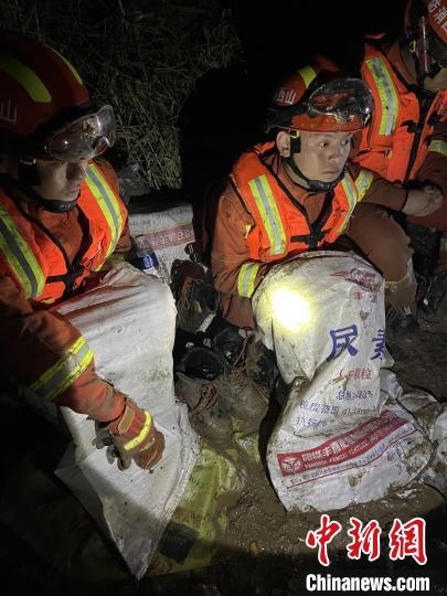 短暫修整期間，消防員脫掉鞋襪，用編織袋套住腿腳保暖。　閆旭輝 攝
