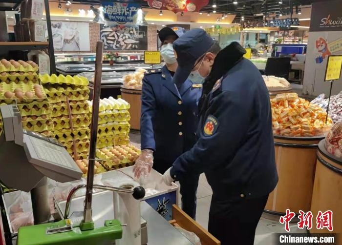 圖為疫情期間，甘肅嘉峪關(guān)市場監(jiān)管局工作人員檢查蔬菜市場?！?柴佳楠 　攝