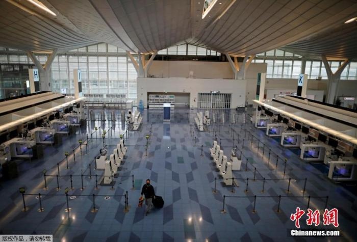 資料圖：日本東京，東京國際機場，一名乘客在國際航班航站樓的登機區(qū)。