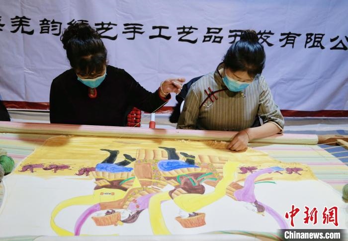 圖為皮繡藝人在市集上“秀”指尖技藝?！●R銘言 攝