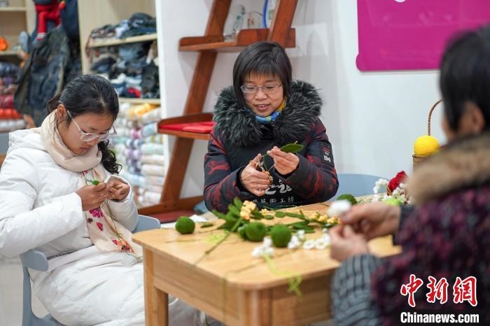 文創(chuàng)工作室的姐妹們正在鉤織月桂葉片。　古良駒 攝