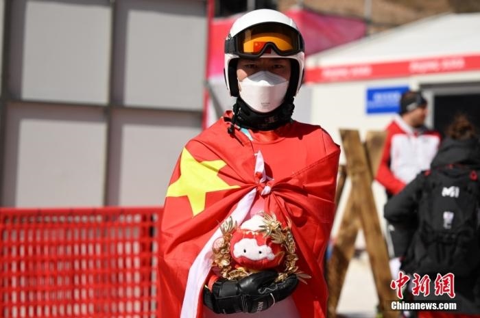 3月6日，中國選手梁景怡在賽后手捧吉祥物。當(dāng)日，北京2022年冬殘奧會(huì)殘奧高山滑雪男子超級大回轉(zhuǎn)-站姿決賽在國家高山滑雪中心舉行，中國選手梁景怡奪得冠軍。 <a target='_blank' href='/'>中新社</a>記者 劉冉陽 攝 　