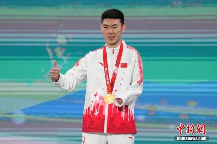 3月6日，梁景怡在延慶頒獎(jiǎng)廣場領(lǐng)獎(jiǎng)臺(tái)上豎起大拇指。當(dāng)日，在國家高山滑雪中心舉行的北京2022年冬殘奧會(huì)殘奧高山滑雪男子超級大回轉(zhuǎn)—站姿決賽中，中國選手梁景怡奪得冠軍。 <a target='_blank' href='/'>中新社</a>記者 楊華峰 攝