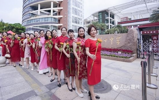 6月7日一早，廈門(mén)雙十中學(xué)考生家長(zhǎng)們身穿旗袍，手拿向日葵在考場(chǎng)外為孩子加油打氣，寓意“旗開(kāi)得勝，一舉奪魁”。人民網(wǎng)記者 陳博攝