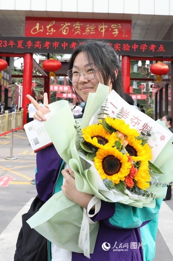 6月7日高考首日，山東67萬(wàn)考生走進(jìn)考場(chǎng)，拼搏逐夢(mèng)。在山東省實(shí)驗(yàn)中學(xué)考點(diǎn)，考生進(jìn)考場(chǎng)前手捧向日葵花拍照留念，寓意“一舉奪魁”。人民網(wǎng)記者 劉祺攝