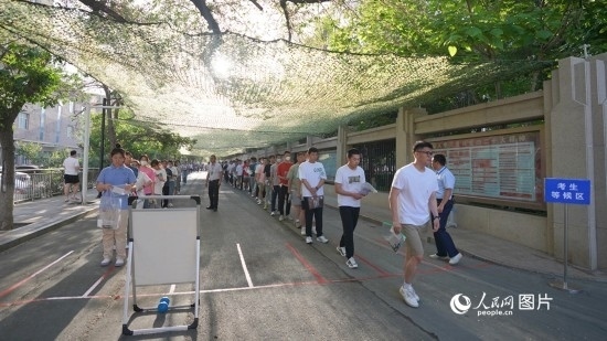 6月7日，烏魯木齊市第七十中學(xué)門(mén)口，考生們有序進(jìn)入考場(chǎng)。人民網(wǎng) 李欣洋攝