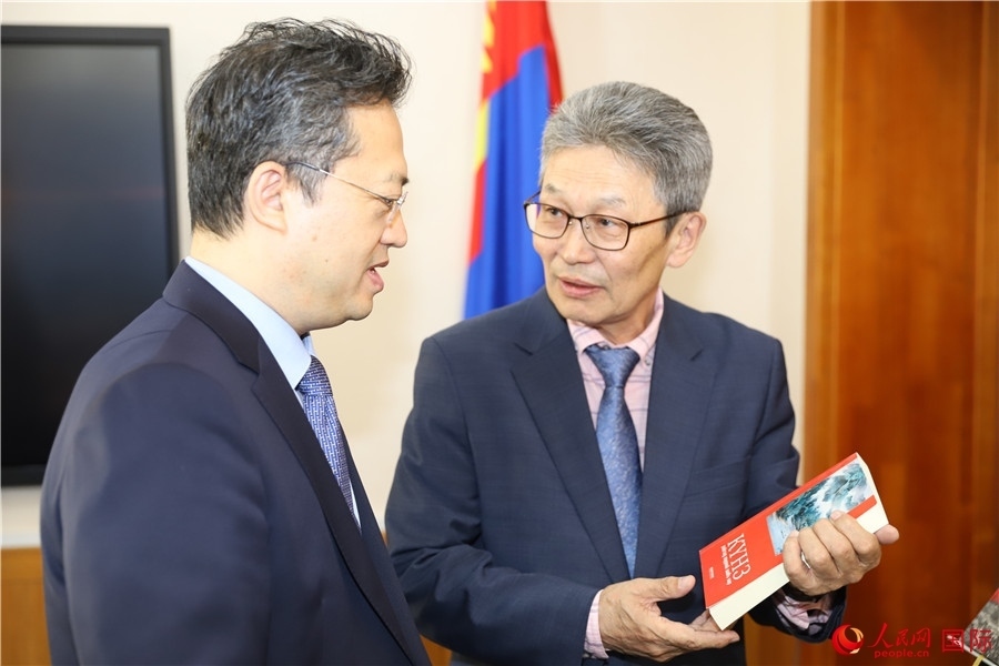 其米德策耶（右一）向李峙介紹翻譯成果。人民網(wǎng)記者 霍文攝