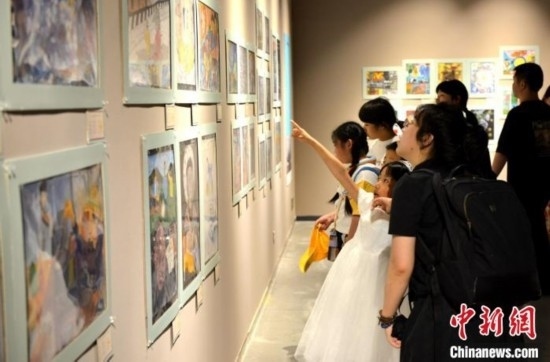 圖為家長帶著孩子參觀展覽。呂明 攝