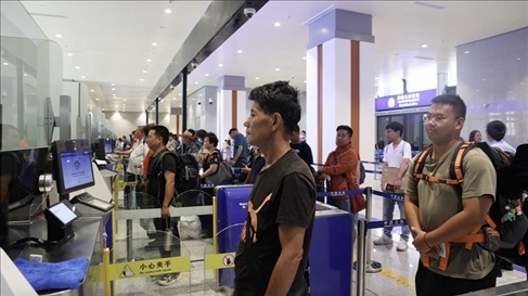 6月13日，乘坐中老鐵路國際旅客列車的旅客在磨憨邊檢大廳排隊候檢。李揚 攝