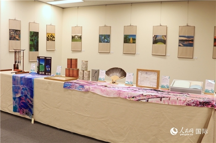 現(xiàn)場展出的馮學敏攝影作品與湖州市特色工藝品。（人民網(wǎng) 許可攝）
