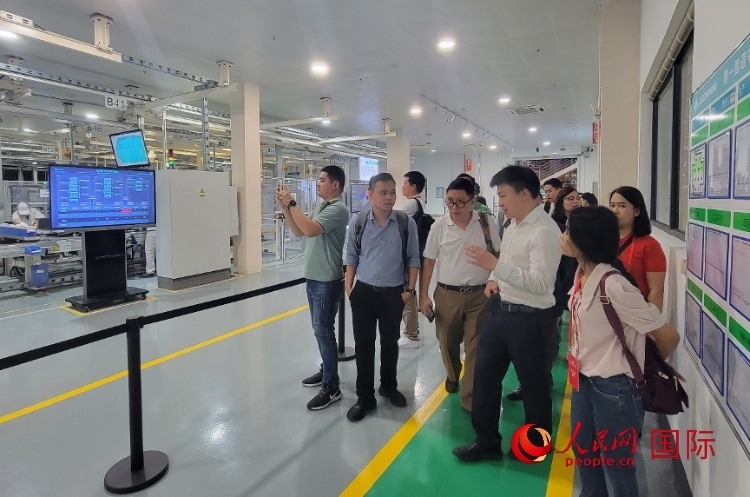 廣汽埃安工作人員向外媒記者進(jìn)行介紹。人民網(wǎng) 寧玉瑛攝