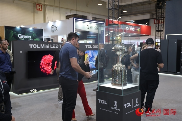 參觀者在TCL展臺前觀看南美解放者杯獎杯，據(jù)介紹，TCL是南美解放者杯（2023—2026賽季）全球官方合作伙伴。（人民網(wǎng)記者 時元皓攝）