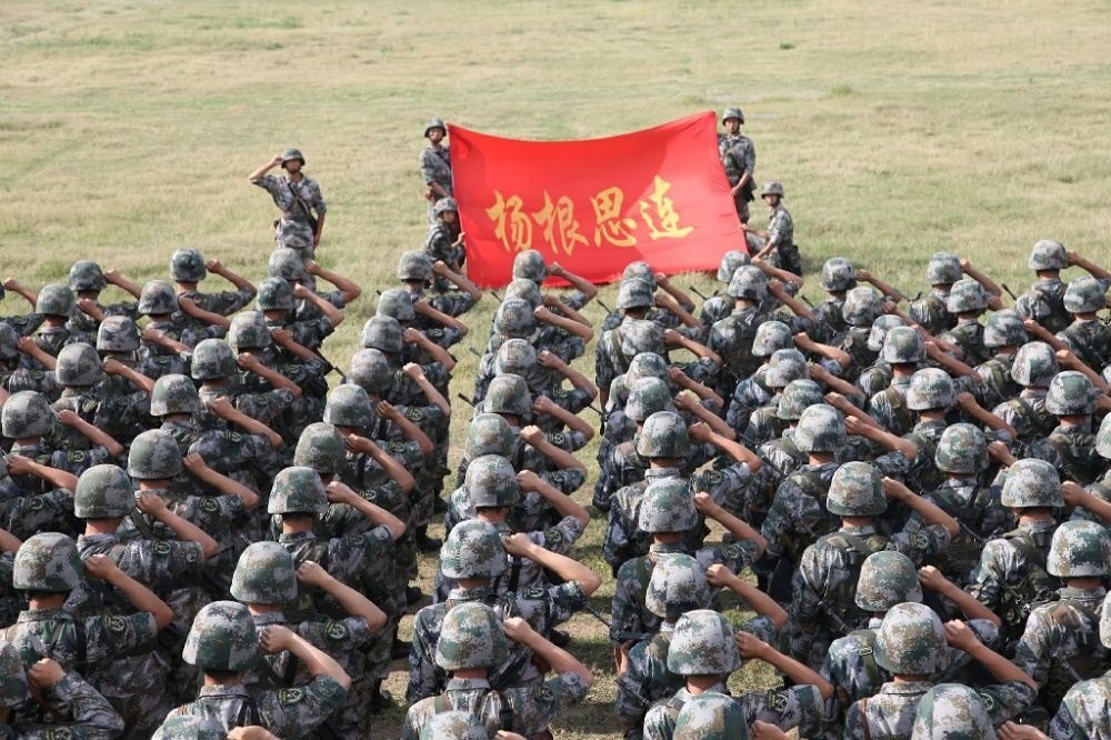 ↑“楊根思連”官兵執(zhí)行任務(wù)前向連旗宣誓（資料照片）。新華社發(fā)