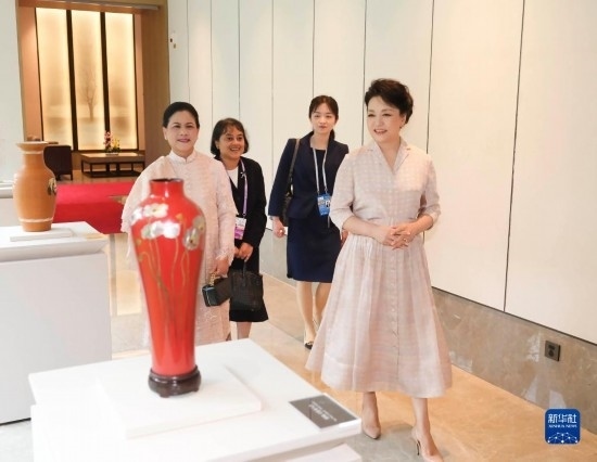 7月27日下午，國家主席習近平夫人彭麗媛在四川成都會見陪同印度尼西亞總統(tǒng)佐科來華出席第31屆世界大學生夏季運動會開幕式并訪華的總統(tǒng)夫人伊莉亞娜。這是彭麗媛和伊莉亞娜欣賞成都特色非遺工藝品。新華社記者 丁林 攝