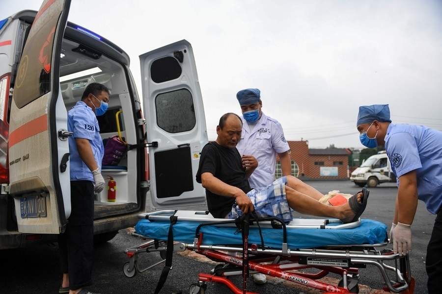 8月1日，在北京市門頭溝區(qū)妙峰山鎮(zhèn)妙峰山民族學(xué)校臨時安置點(diǎn)，北京急救中心工作人員在轉(zhuǎn)運(yùn)一名受傷村民。新華社記者 鞠煥宗 攝