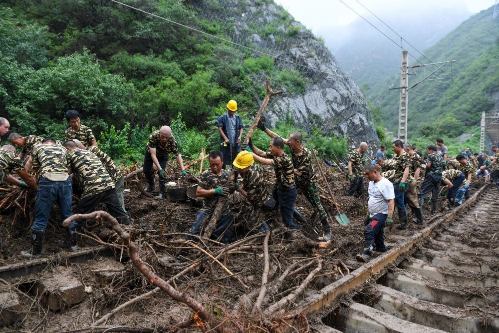 8月1日，在北京市門(mén)頭溝區(qū)水峪嘴村附近一段被阻斷的鐵路線(xiàn)上，中鐵六局工作人員在清理軌道上的雜物，全力恢復(fù)交通。新華社記者 鞠煥宗 攝