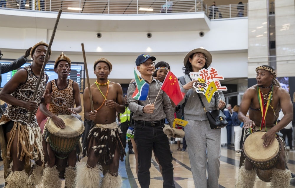 在南非約翰內(nèi)斯堡坦博國際機(jī)場，南非舞蹈演員歡迎中國試點恢復(fù)出境團(tuán)隊旅游后首批抵達(dá)南非的中國游客（2023年3月29日攝）。