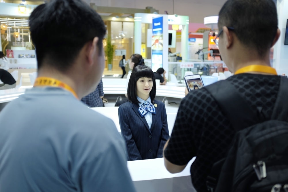 9月1日，媒體記者在國家會(huì)議中心與服務(wù)機(jī)器人互動(dòng)。新華社記者 劉夢(mèng)琪 攝