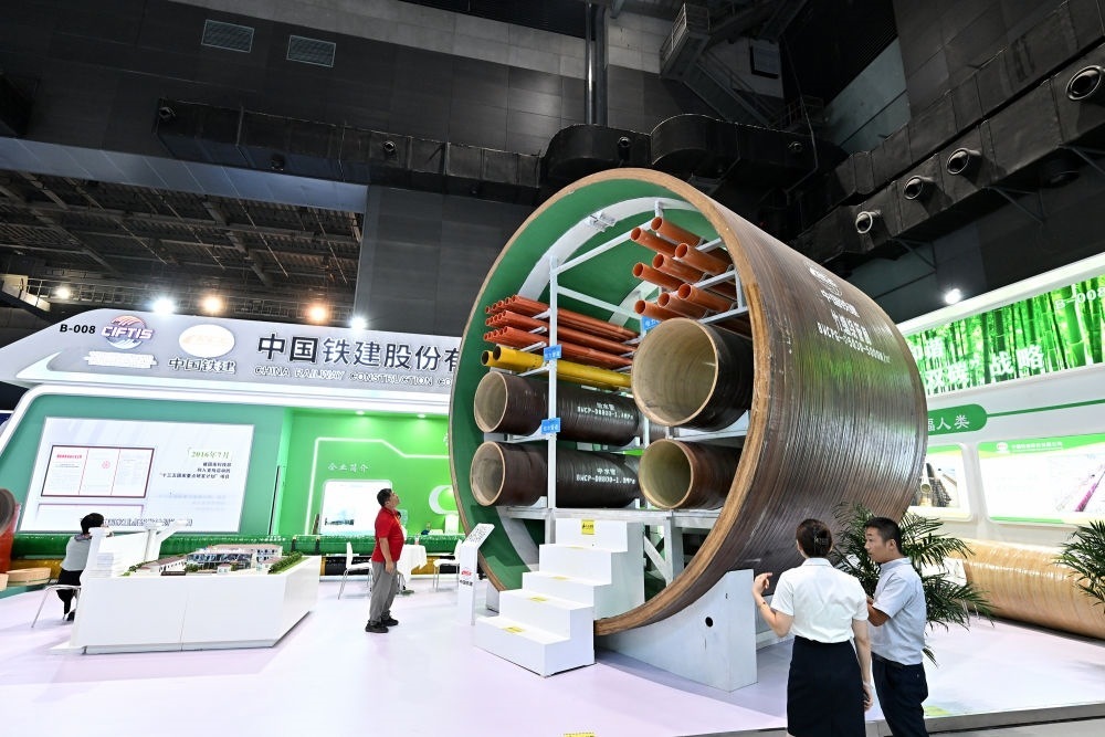 9月2日，在國(guó)家體育館舉行的服貿(mào)會(huì)環(huán)境服務(wù)專(zhuān)題展上，客商在中國(guó)鐵建展位竹纏繞管廊旁了解信息。新華社記者 李鑫 攝