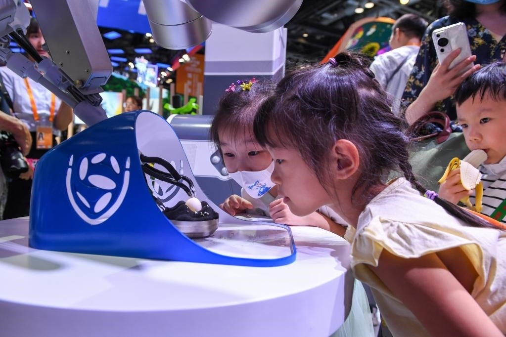 9月3日，幾名小朋友在國家會議中心觀看單孔腔鏡手術(shù)機器人展示。新華社記者 鞠煥宗 攝