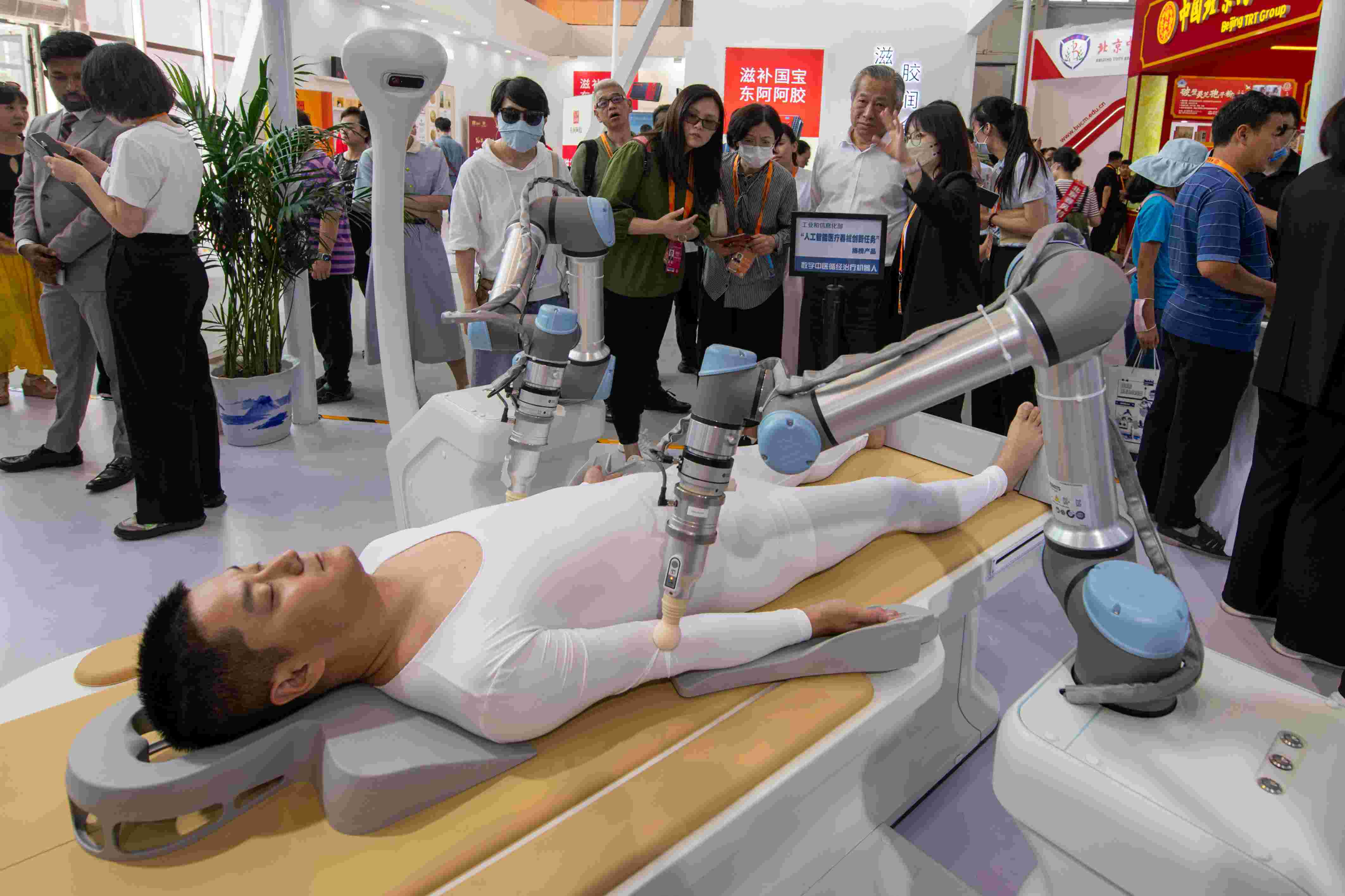 在位于首鋼園的健康衛(wèi)生服務(wù)展區(qū)，觀眾正在參觀數(shù)字中醫(yī)循經(jīng)治療機(jī)器人。人民網(wǎng)記者 翁奇羽攝