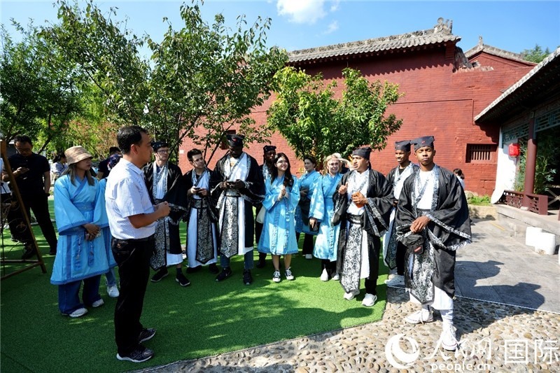 圖為選手們聽導(dǎo)游講解。人民網(wǎng) 盧鵬宇攝