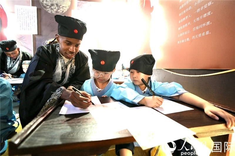 圖為選手與同學(xué)們一起寫書法。人民網(wǎng) 盧鵬宇攝