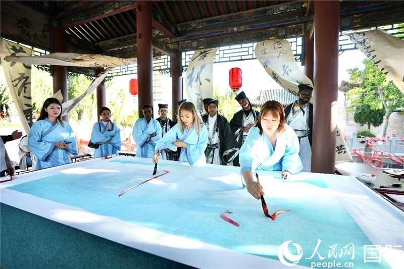 選手們提筆書寫“家園”二字。人民網(wǎng) 盧鵬宇攝