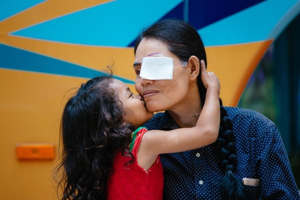 2019年3月15日，在柬埔寨磅湛省醫(yī)院，即將接受白內(nèi)障手術(shù)的患者孫美樂接受女兒的親吻祝福。在接受了中國醫(yī)療隊的白內(nèi)障義診手術(shù)后，她的視力逐步恢復(fù)，生活有了新的光明和希望。