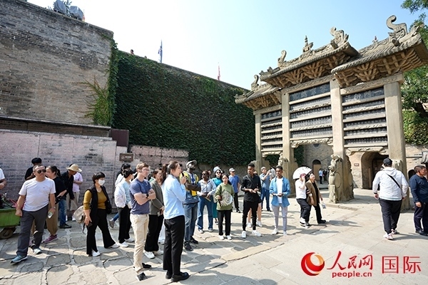 選手們認(rèn)真聆聽導(dǎo)游講解。人民網(wǎng) 盧鵬宇攝