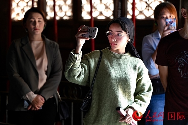 選手顏青（蘇丹）用手機記錄所見所感。人民網(wǎng) 盧鵬宇攝