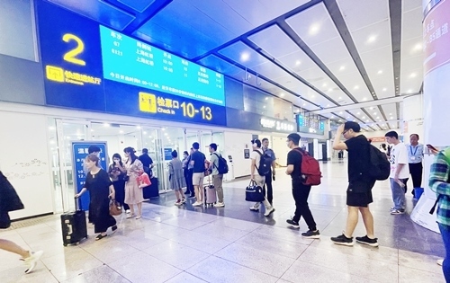 在快速進(jìn)站廳前排隊等待檢票的旅客。人民網(wǎng)記者 喬雪峰攝