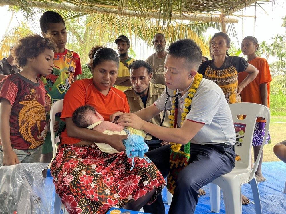 2023年8月5日，在巴布亞新幾內亞中央省的一個村莊里，第12批援巴新中國醫(yī)療隊副隊長、新生兒科副主任醫(yī)師劉振球為當地嬰兒聽診檢查。新華社發(fā)（第12批援巴新中國醫(yī)療隊供圖）