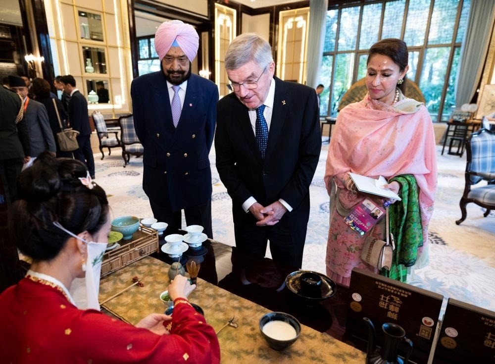 △歡迎宴會前，亞奧理事會代理主席辛格和夫人維尼塔、國際奧委會主席巴赫欣賞非遺展示。