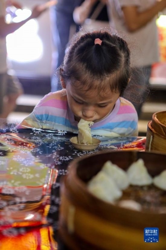 9月27日，小朋友在南翔小籠長(zhǎng)街宴上品嘗南翔小籠。