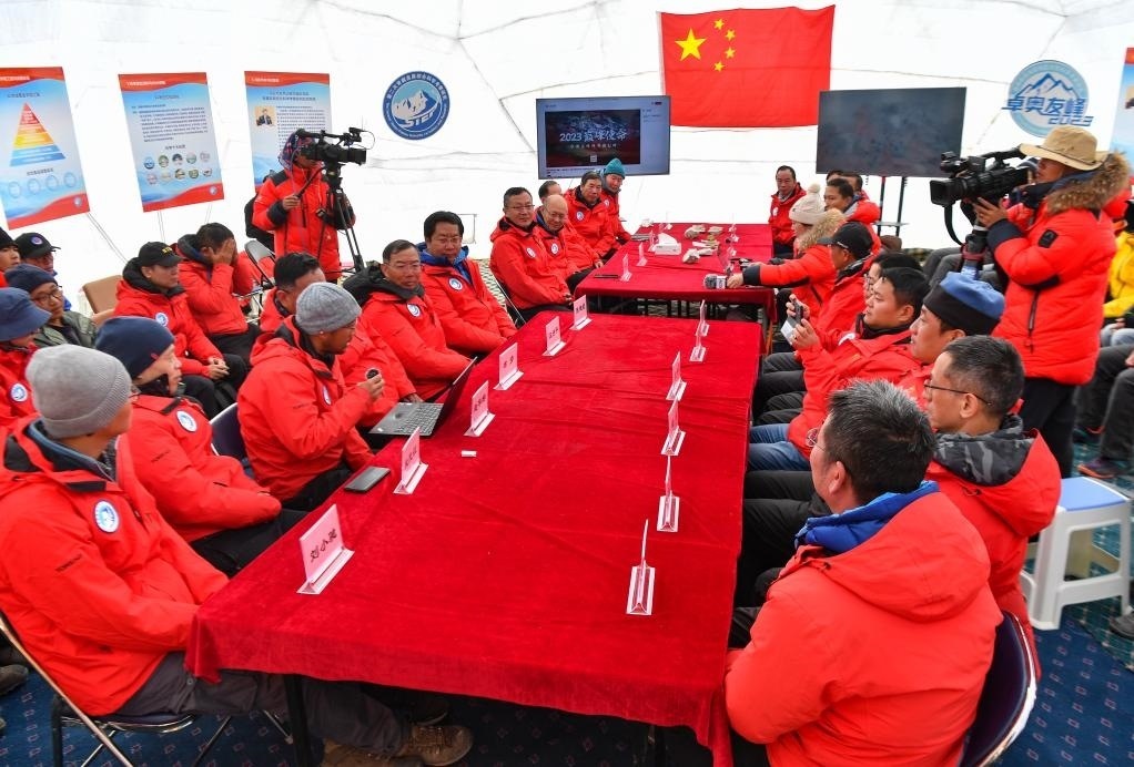 海拔4950米的卓奧友峰科考大本營，科考隊員趙華標（手拿麥克風看電腦者）在宣讀剛剛接收到的頂峰氣象觀測數(shù)據(jù)，這標志著峰頂自動氣象站架設(shè)成功，成功傳回觀測數(shù)據(jù)（10月1日攝）。新華社記者晉美多吉 攝