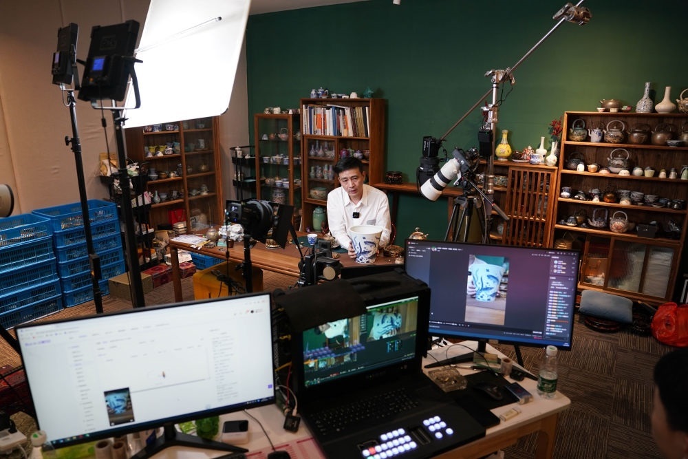 ↑在景德鎮(zhèn)，工作人員通過(guò)網(wǎng)絡(luò)直播推介陶瓷產(chǎn)品（2023年2月22日攝）。