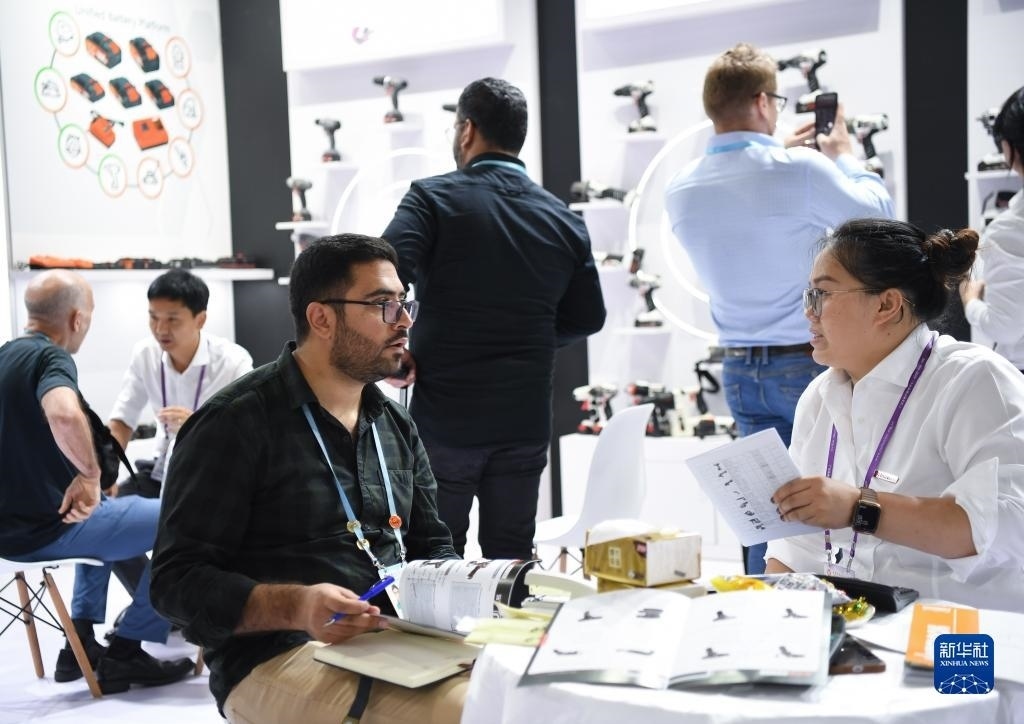 10月15日，在一家電動工具展臺，外國采購商在洽談業(yè)務(wù)。新華社記者 鄧華 攝