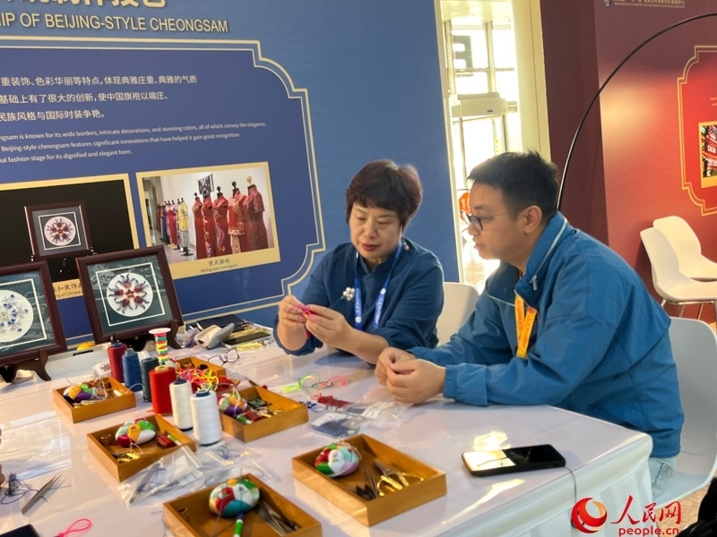 記者在新聞中心非遺傳承人展區(qū)進(jìn)行體驗(yàn)。人民網(wǎng)記者 杜燕飛攝