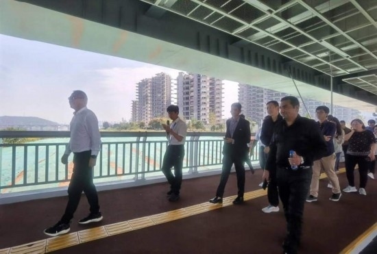 10月24日，2023“一帶一路”媒體合作論壇聯(lián)合采訪團團員走在清水塘大橋景觀通道上。本報記者 常雯宜攝