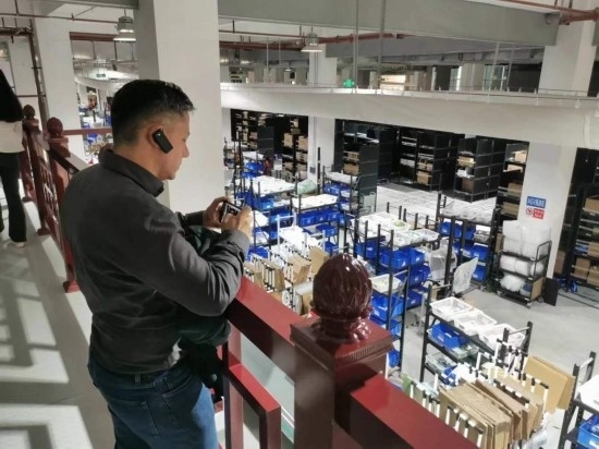 2023“一帶一路”媒體合作論壇聯(lián)合采訪團(tuán)團(tuán)員在仁和醫(yī)藥物流園拍攝記錄轉(zhuǎn)運流程。（本報記者 黃超攝）