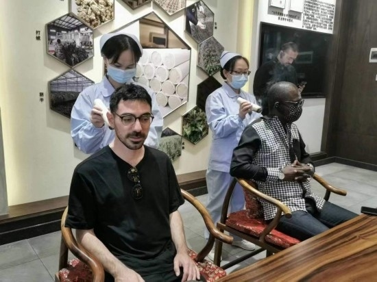 2023“一帶一路”媒體合作論壇聯(lián)合采訪團(tuán)團(tuán)員在九牛草展示館體驗艾灸。（本報記者 黃超攝）