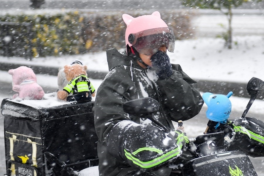 11月6日，在長春市街頭，一名外賣員在雪中騎行。新華社記者 許暢 攝