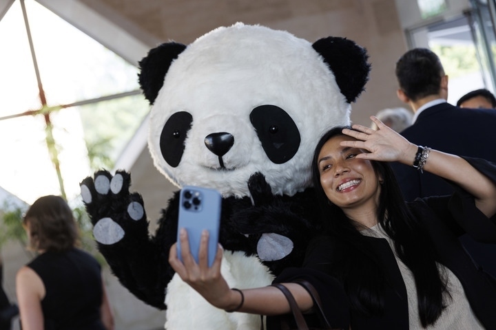2022年8月24日，在美國華盛頓中國駐美國大使館，來賓與大熊貓玩偶合影。