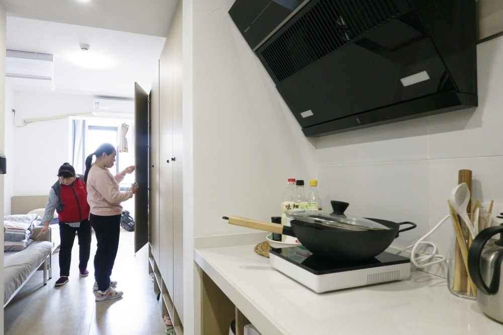 住戶在閔行區(qū)新時代城市建設者管理者之家收拾房間。