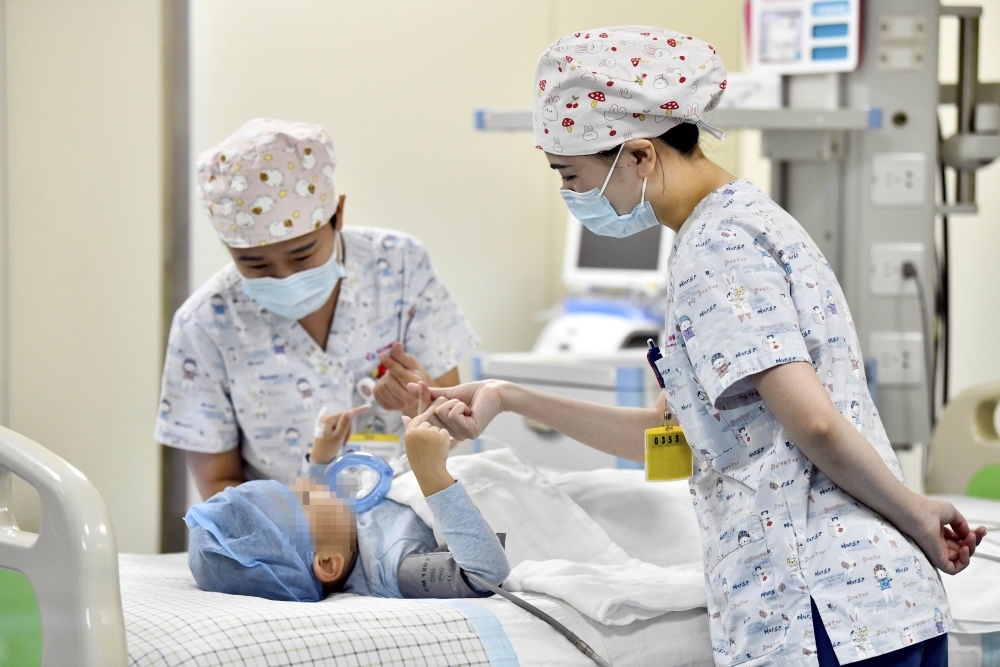 在山東省棗莊市婦幼保健院兒童ICU病房，醫(yī)護(hù)人員為完成靶向治療藥物諾西那生鈉的4歲脊髓性肌萎縮癥患兒加油鼓勁（2022年1月1日攝）。諾西那生鈉注射液是我國(guó)首個(gè)獲批治療脊髓性肌萎縮癥的進(jìn)口藥物，2019年進(jìn)入中國(guó)市場(chǎng)時(shí)，每針價(jià)格近70萬(wàn)元。在2021年國(guó)家醫(yī)保目錄藥品談判中，以3.3萬(wàn)元每針的價(jià)格進(jìn)入新版醫(yī)保藥品目錄。新華社記者 郭緒雷 攝