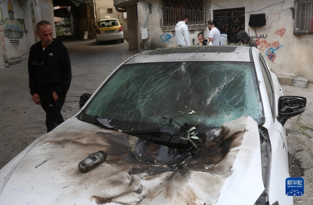 12月17日，在約旦河西岸城市圖勒凱爾姆附近的一處難民營(yíng)，人們查看在沖突中損毀的車輛。新華社發(fā)（尼達(dá)爾·艾仕塔耶?dāng)z）