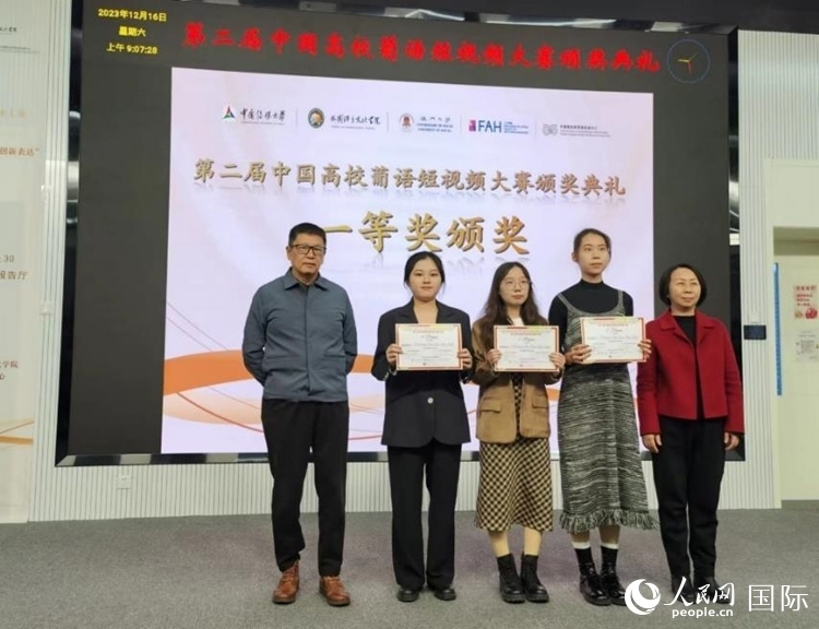 澳門(mén)大學(xué)中葡雙語(yǔ)教學(xué)暨培訓(xùn)中心主任姚京明（左一）和中國(guó)傳媒大學(xué)外國(guó)語(yǔ)言文化學(xué)院院長(zhǎng)文春英（右一）為一等獎(jiǎng)獲得者頒獎(jiǎng)。人民網(wǎng)記者 魯揚(yáng)攝