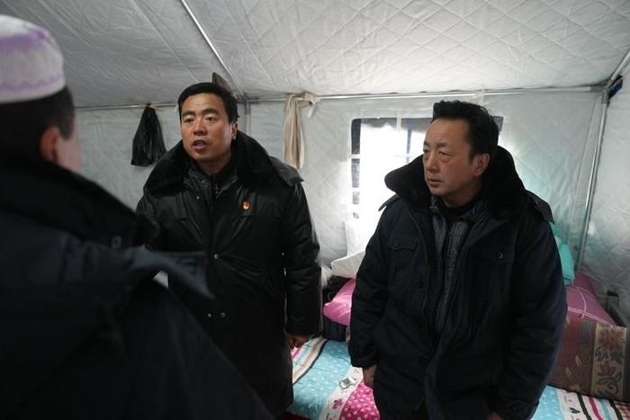 2023年12月22日，積石山縣大河家鎮(zhèn)大河村黨支部書記馬成忠（右二）在帳篷里和受災(zāi)群眾交流。新華社記者 陳斌 攝