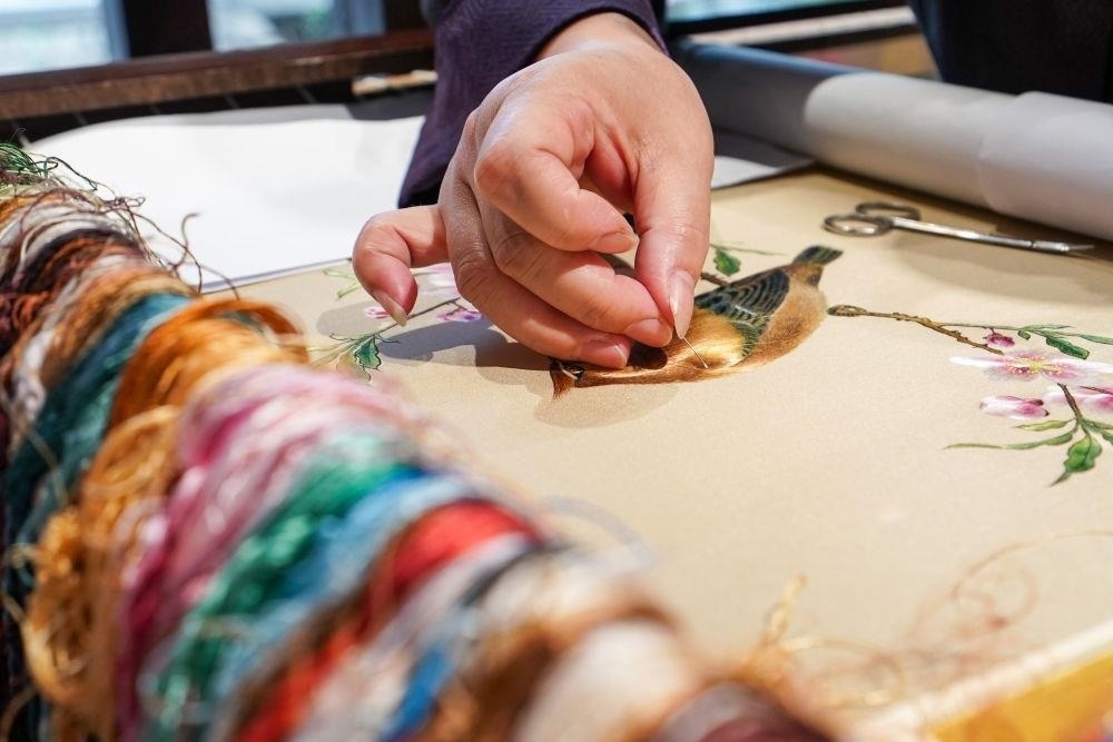 △2023年7月6日，盧建英在江蘇蘇州平江路的工作室內(nèi)刺繡。